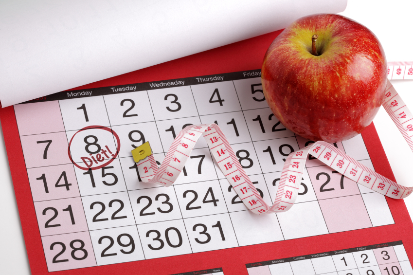 Dieting concept apple and tape measure on a calendar with a date to start a diet